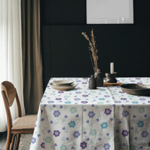 Aranżacja stołu z ceramiką na obrusie w drobne kwiaty, widoczne nasycone turkusowe i fioletowe akcenty