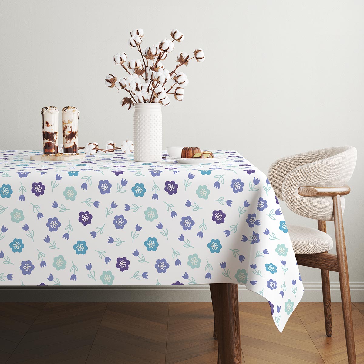 Stół nakryty obrusem z motywem kwiatowym w jasnym wnętrzu z dekoracyjnym wazonem