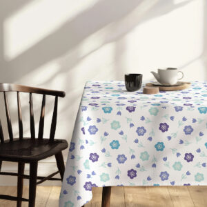 Widok rogu stołu z obrusu ukazujący regularny powtarzalny wzór i fakturę tkaniny