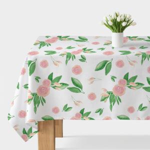 obrus rozłożony na stole z różowymi pąkami i zielonymi liśćmi