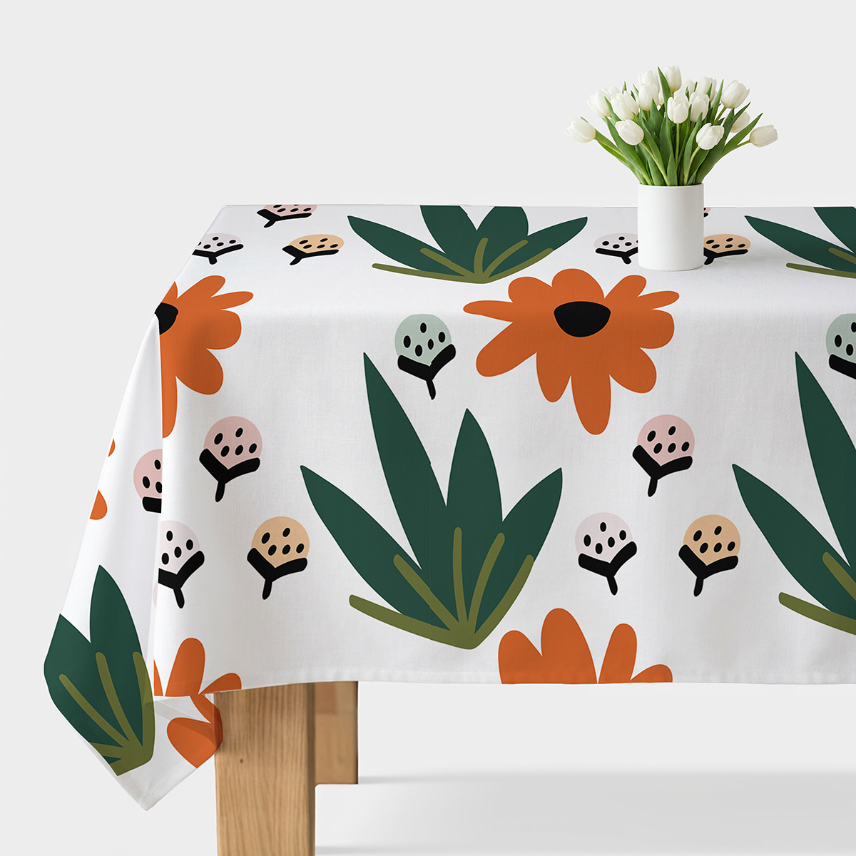 obrus z graficznym wzorem dużych pomarańczowych kwiatów i zielonych liści na białym tle, widok stołu