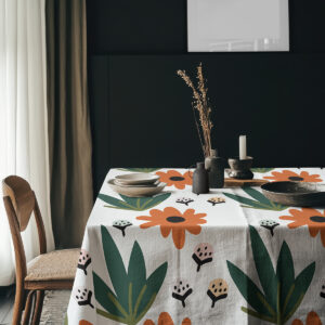 aranżacja stołu z obrusem i dekoracjami ceramicznymi na tle ciemnej ściany