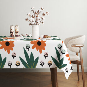 stołowa aranżacja z wazonem i deserem na obrusem z motywem kwiatowym