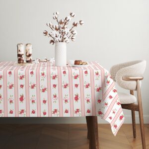 Obrus na stole z wazonem bawełnianych kwiatów i drobnymi dekoracjami