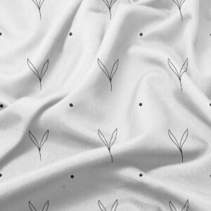 Zbliżenie na tkaninę pokazujące szczegółowy, ręcznie rysowany motyw listków i rozmieszczone kropki