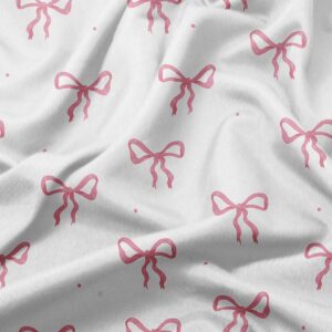 zbliżenie na tkaninę obrusy z różowymi kokardkami ukazujące fakturę i nadruk