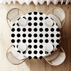 Widok z góry na okrągły stół przykryty obrusem z dużymi czarnymi kropkami