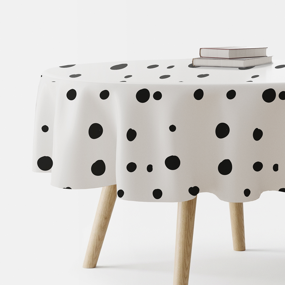 Okrągły obrus z nieregularnymi czarnymi grochami na białym tle, widok z boku stołu