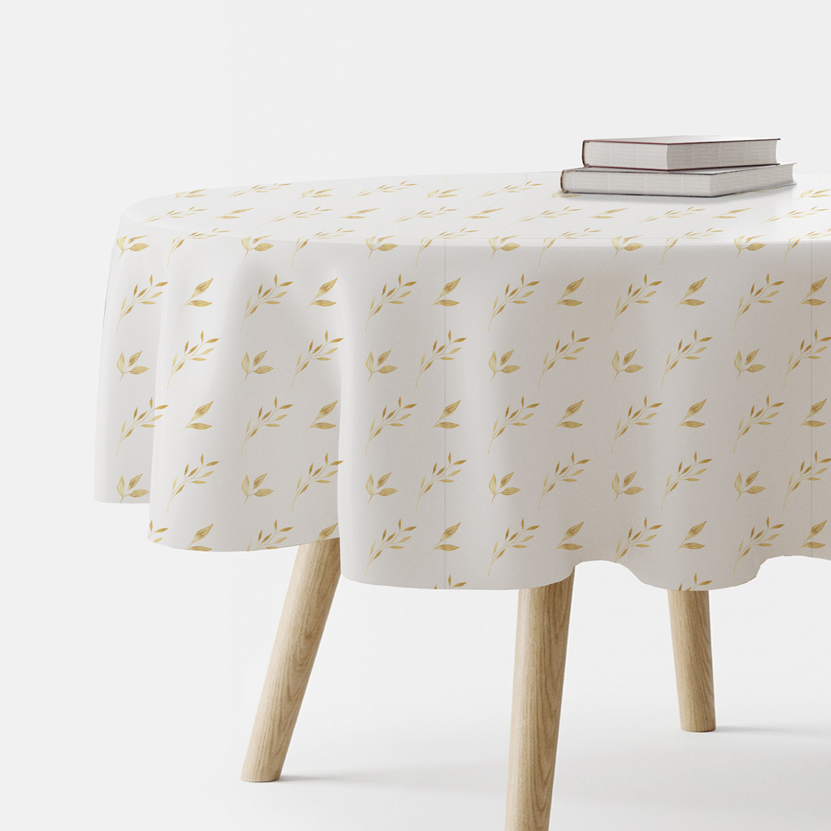okrągły obrus na stole z delikatnym, powtarzalnym wzorem złotych listków