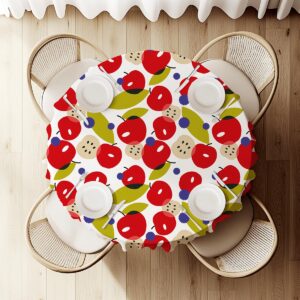 widok z góry na okrągły stół pokryty obrusem z powtarzalnym motywem jabłek