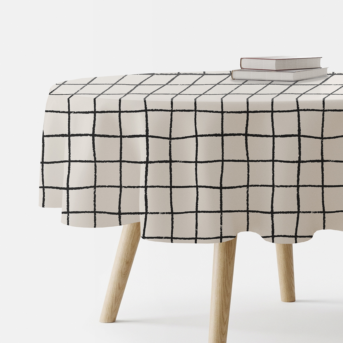 Okrągły obrus z kremowym tłem i czarną, ręcznie malowaną kratą na stole