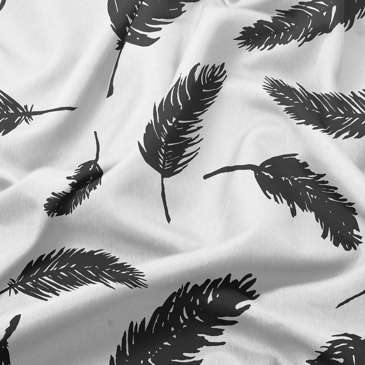 detal tkaniny z wyraźnymi, graficznymi czarnymi piórami