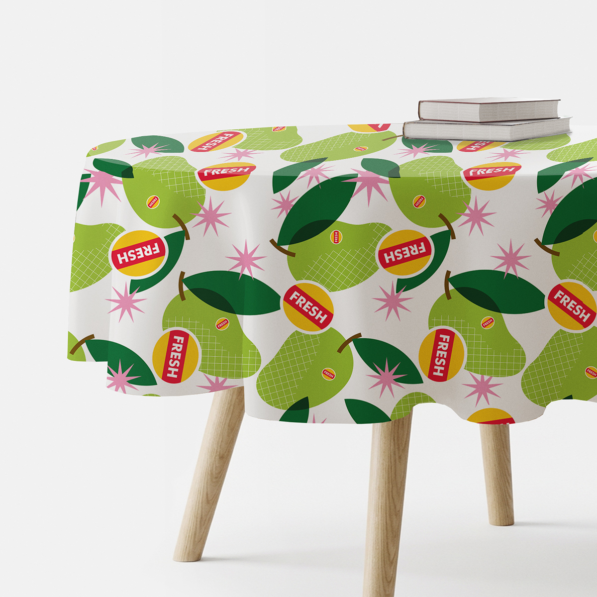 okrągły obrus z wzorem zielonych gruszek i różowych gwiazdek na stole