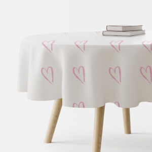 okrągły stół nakryty białym obrusem z różowymi akwarelowymi sercami, widok na brzeg stołu