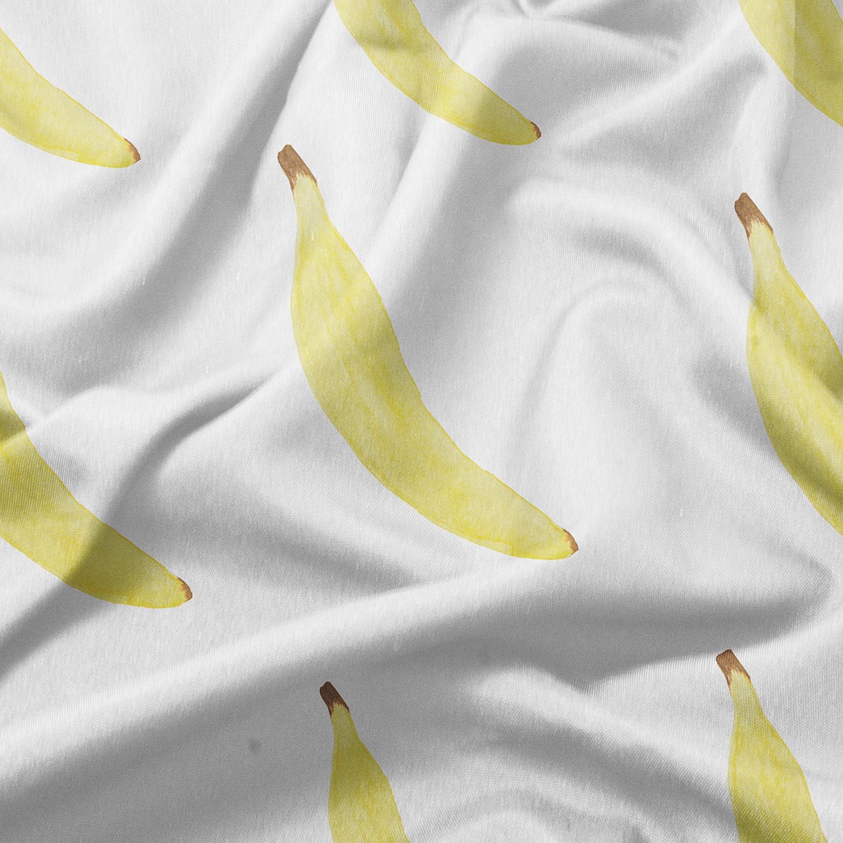 zbliżenie tkaniny z akwarelowymi bananami i widoczną fakturą materiału