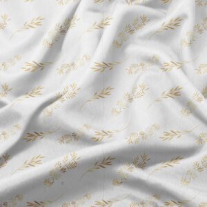 zbliżenie tkaniny obrusa pokazujące delikatny nadruk złotych gałązek i fakturę materiału