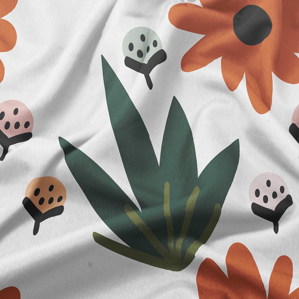 zbliżenie na nadruk z ciemnozielonym liściem i pomarańczowym kwiatem na jasnym tle