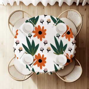 widok z góry na okrągły stół z obrusem w motyw kwiatowy i ustawioną zastawą