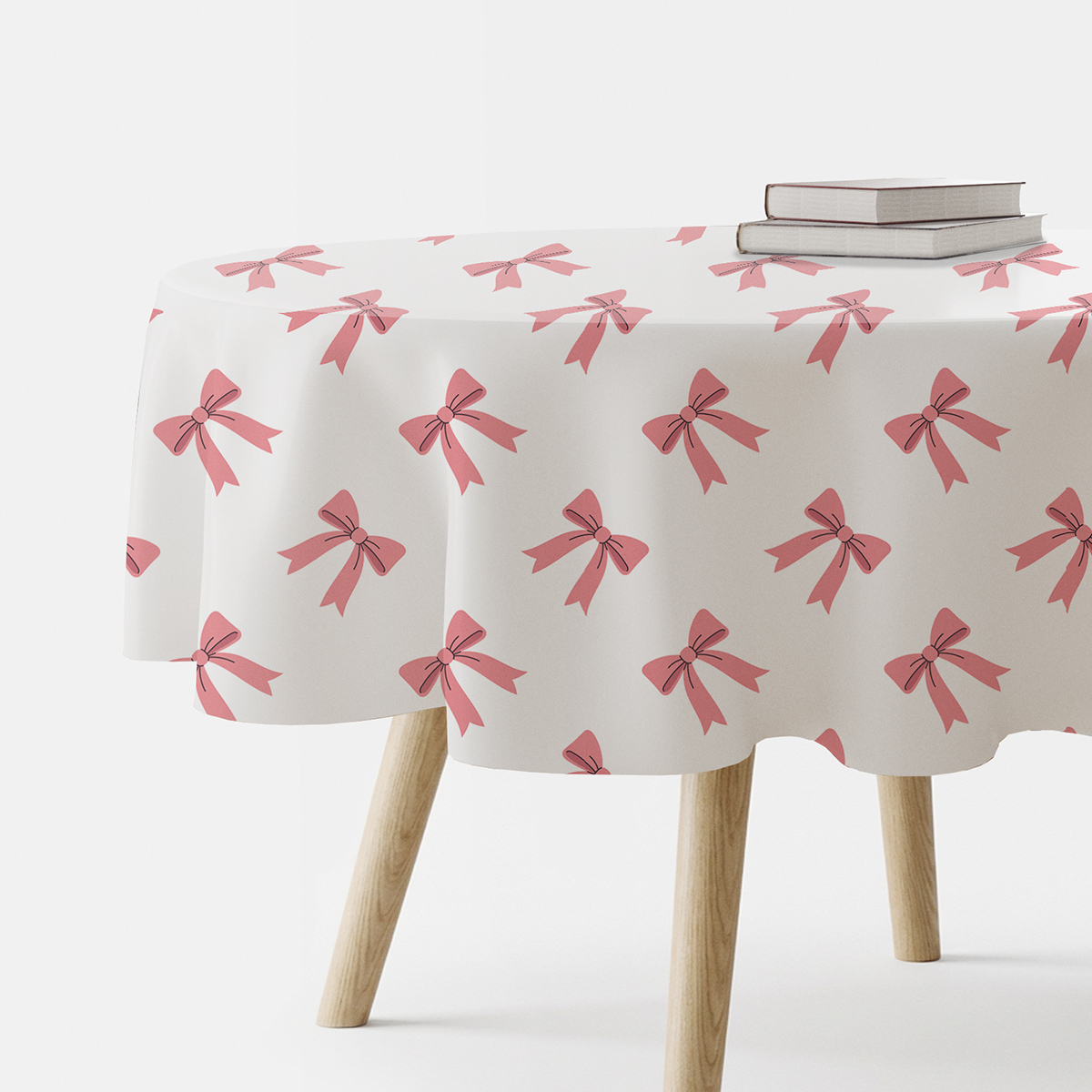 okrągły obrus na stoliku z powtarzającym się wzorem różowych kokardek