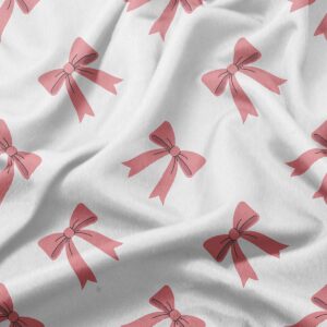 zbliżenie tkaniny z motywem różowych kokardek i delikatną fakturą materiału