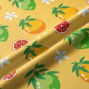 Zbliżenie na tkaninę z wzorem limonek, pomarańczy i drobnych białych kwiatków