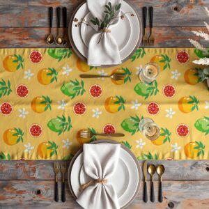 Styling stołu z bieżnikiem w cytrusowy deseń, zastawą i złotymi sztućcami