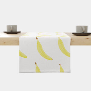 Bieżnik z motywem żółtych bananów rozłożony na drewnianym stole w stylowej aranżacji