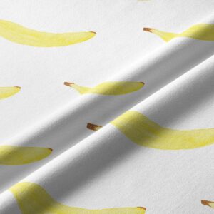 Zbliżenie tkaniny pokazujące akwarelowe nadruki bananów i fakturę materiału