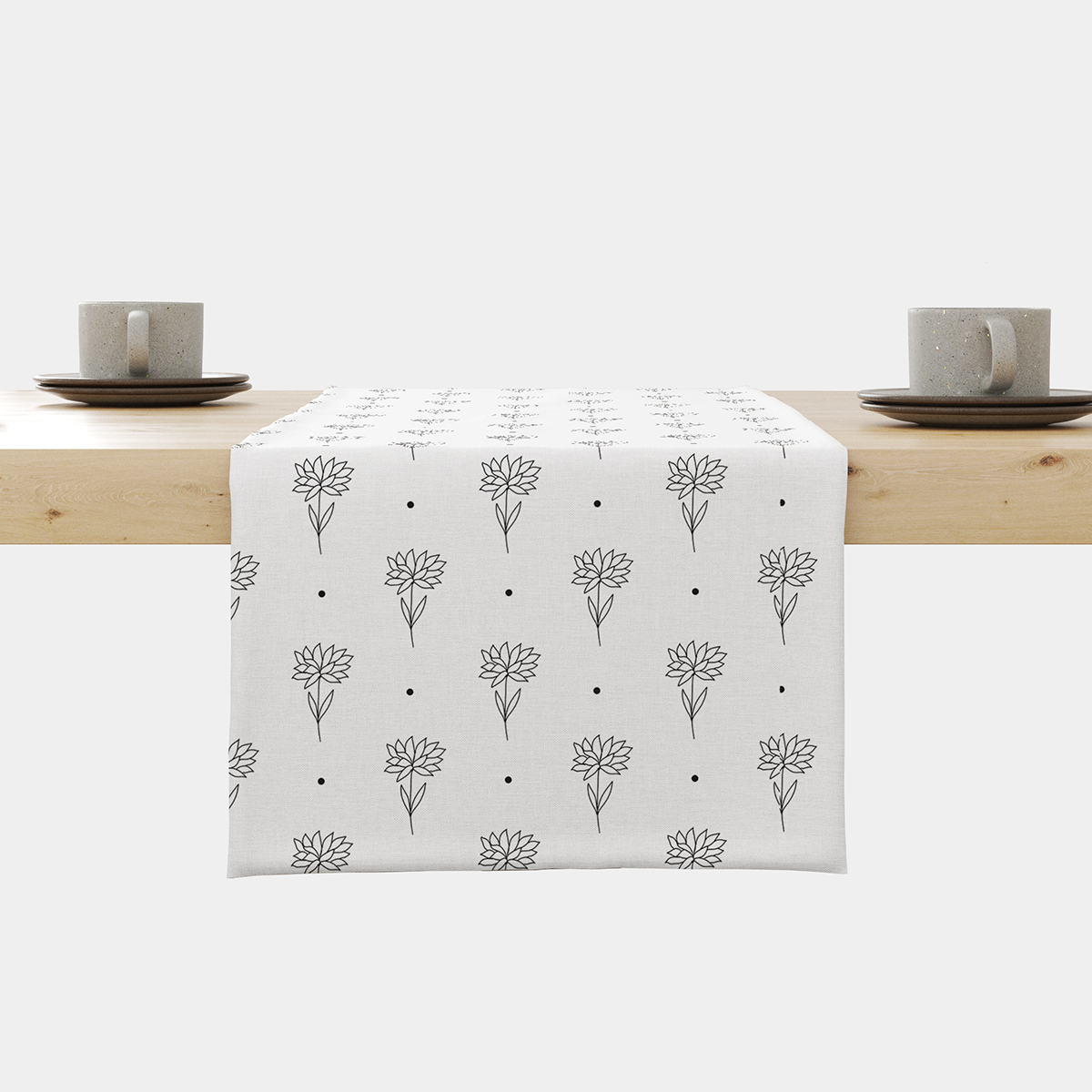 biały bieżnik z czarnymi rysunkowymi kwiatuszkami rozłożony na stole, widok z przodu