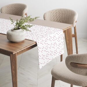 Bieżnik rozłożony na drewnianym stole w jasnej, skandynawskiej aranżacji