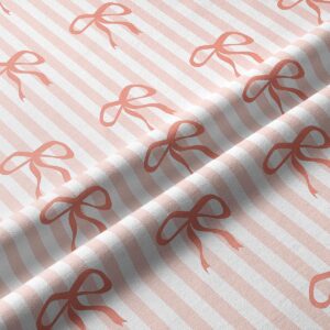 Zbliżenie na fakturę tkaniny i powtarzający się wzór kokardek na paskach