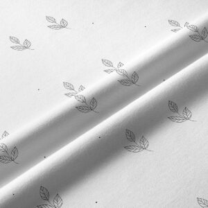 Zbliżenie na tkaninę i delikatny nadruk liści z pojedynczymi kropkami