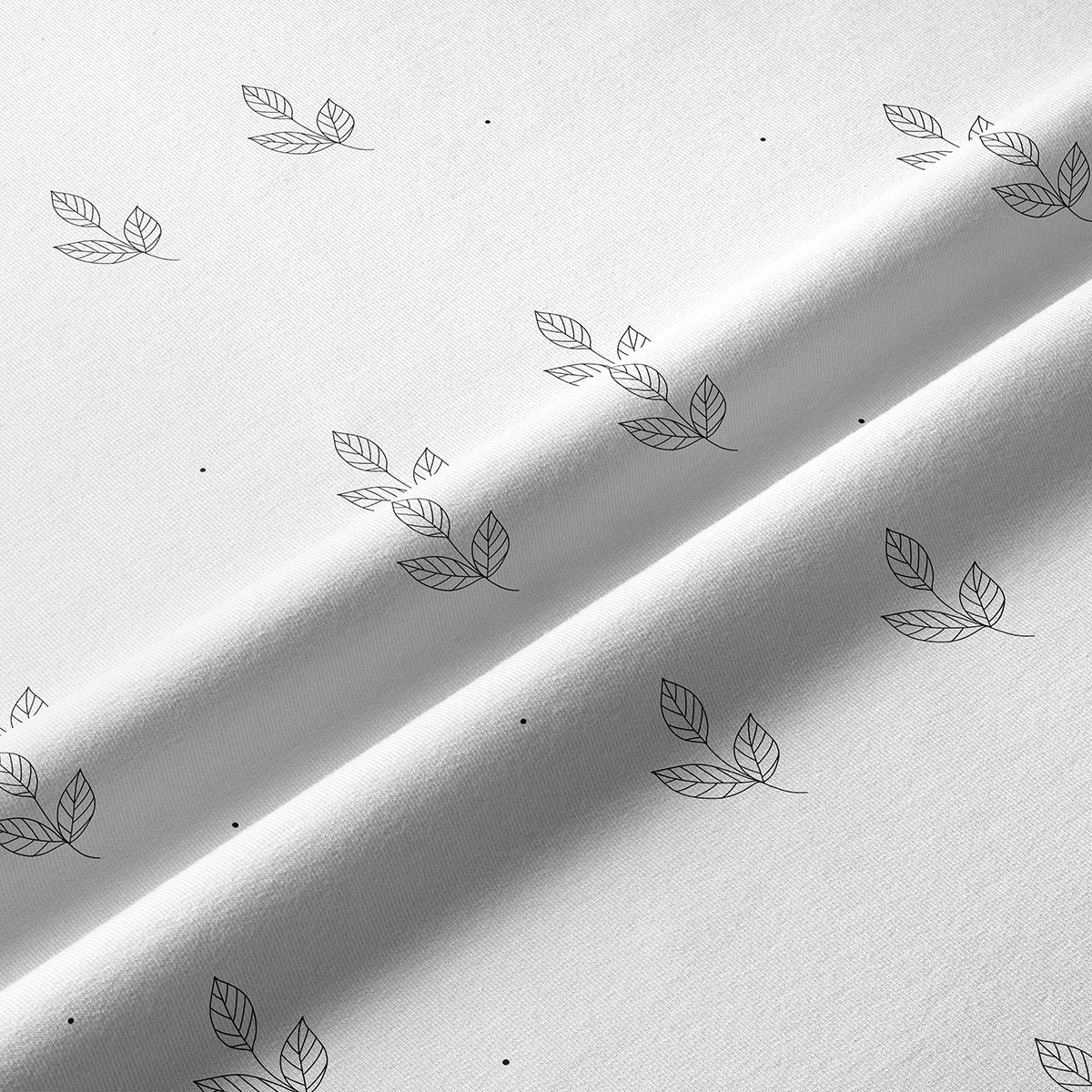 Zbliżenie na tkaninę i delikatny nadruk liści z pojedynczymi kropkami