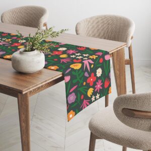 Bieżnik rozciągnięty na drewnianym stole widok z boku z detalami roślinnego motywu