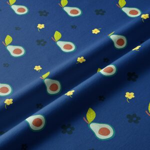 Zbliżenie materiału z grafiką połówek awokado i małych kwiatuszków na granatowym tle