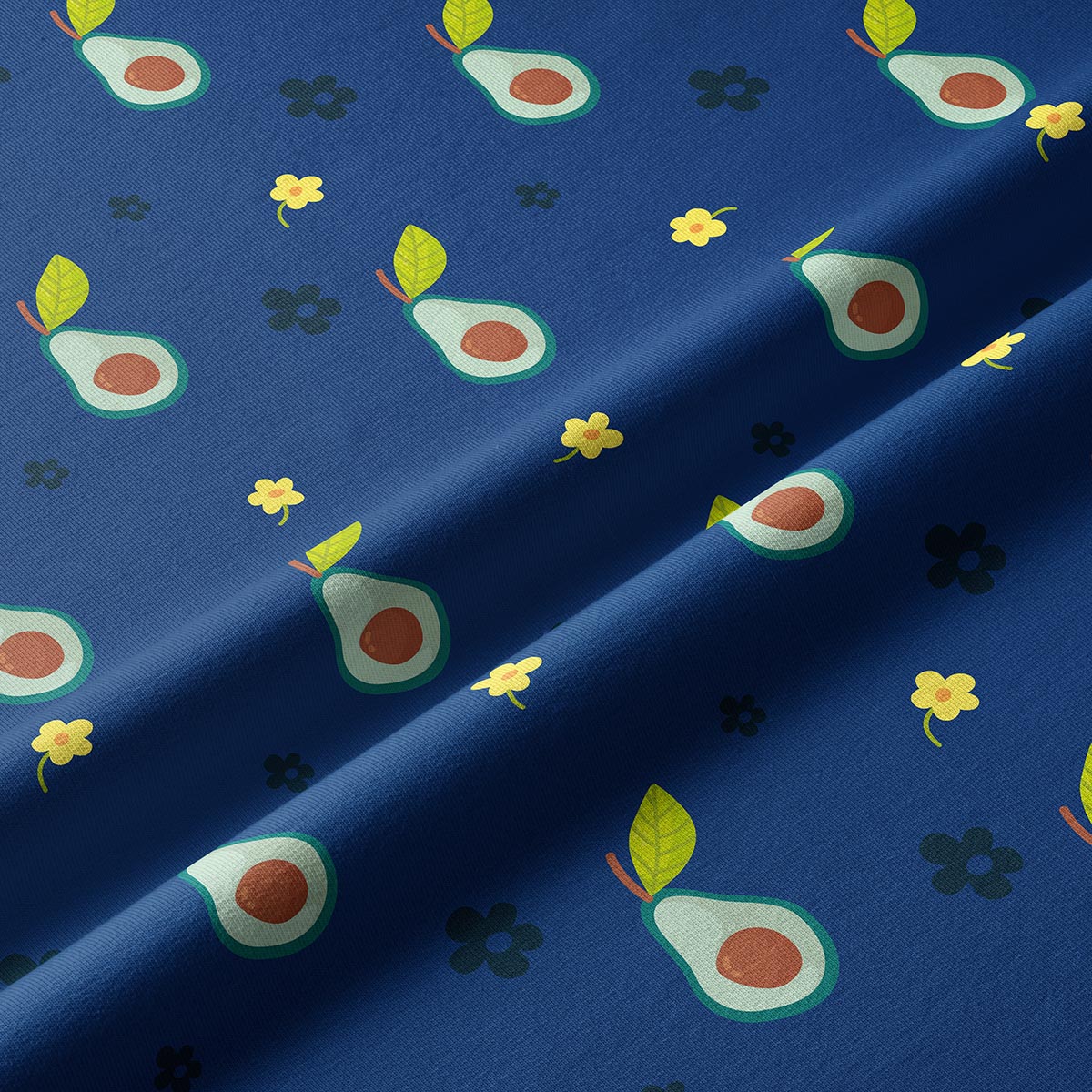 Zbliżenie materiału z grafiką połówek awokado i małych kwiatuszków na granatowym tle