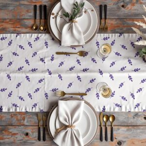 Stół nakryty bieżnikiem w aranżacji z talerzami, złotymi sztućcami i serwetką