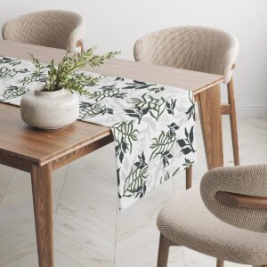 Widok boczny bieżnika na drewnianym stole z donicą i krzesłami w tle