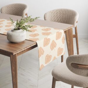 Bieżnik rozłożony na drewnianym stole z dekoracyjnym wazonem