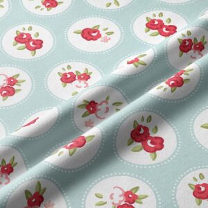 Zbliżenie na fakturę tkaniny i detal czerwono-różowych kwiatuszków w białych okręgach