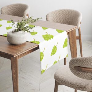 bieżnik z motywem winogron na jasnym stole, widok z boku z dekoracyjną wazą