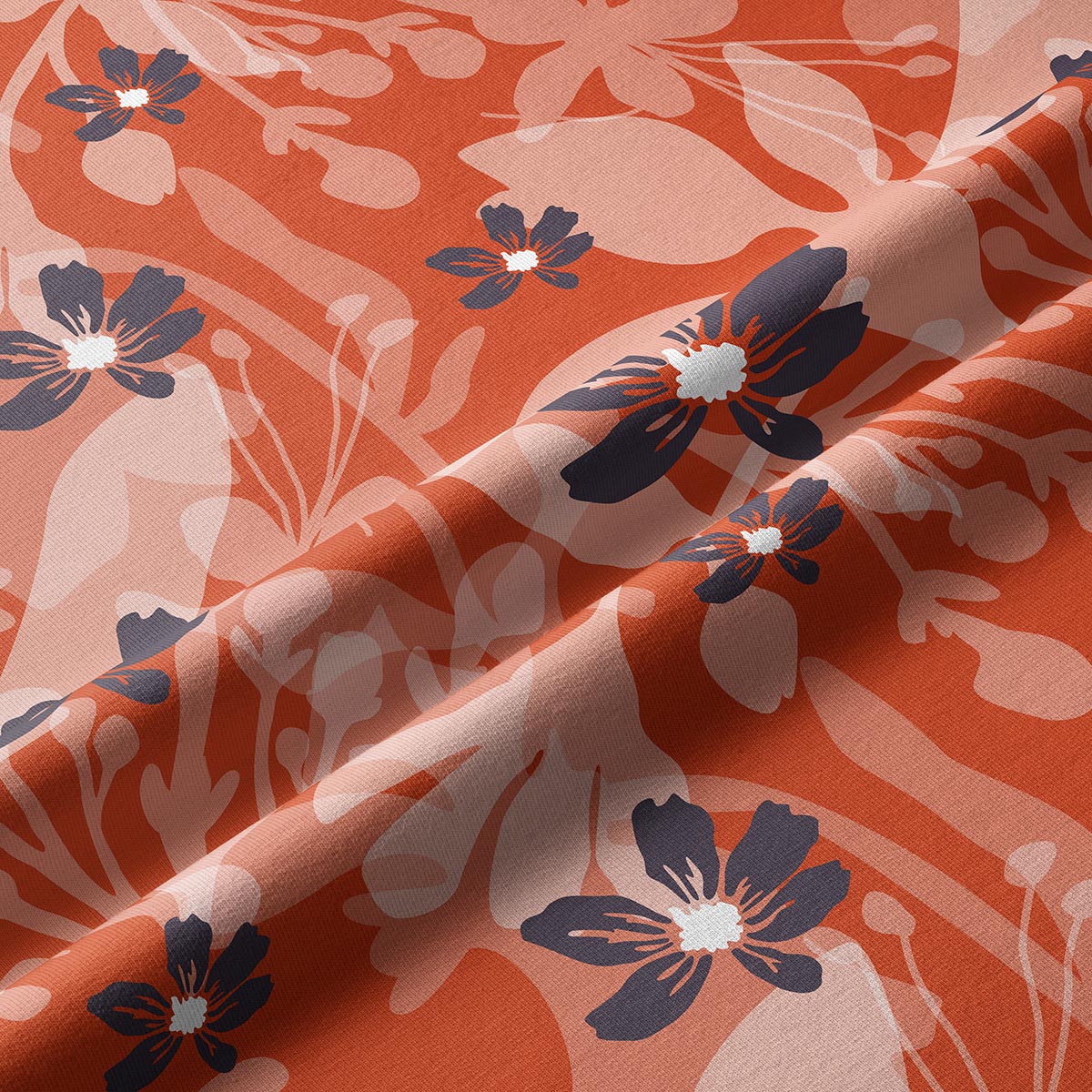 Zbliżenie na tkaninę pokazujące detale nadruku i granatowe kwiaty na ceglastym tle