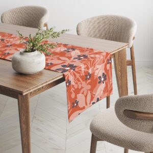 Kąt stołu z bieżnikiem, widoczny powtarzalny wzór liści i kwiatów