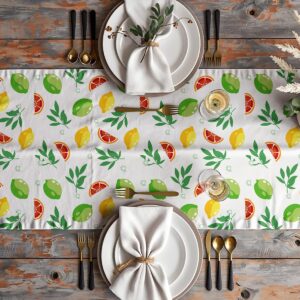 Aranżacja stołu z bieżnikiem, talerze, sztućce i kieliszki tworzą letnią kompozycję