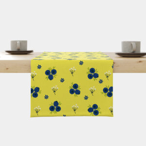 Bieżnik z granatowymi jagódkami na cytrynowym tle ułożony na drewnianym stole