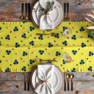 Aranżacja stołu z bieżnikiem o wzorze jagódek, zastawa i kieliszki na tle