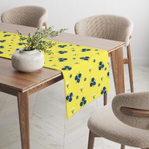 Widok narożnika stołu z bieżnikiem, dekoracja z wazonem i krzesłem w tle