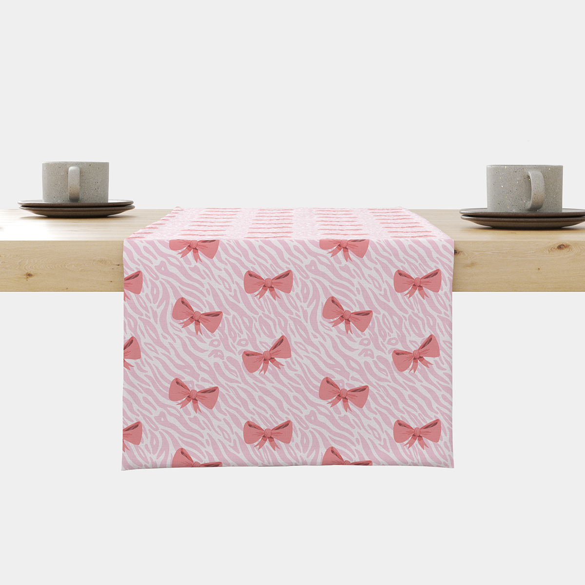 Bieżnik z różowymi kokardkami na delikatnym jasnym tle ułożony na stole