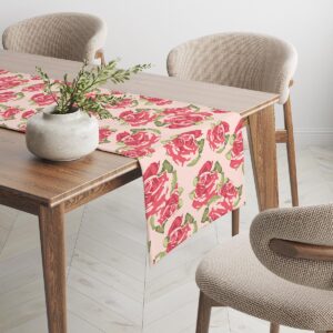 Bieżnik na drewnianym stole z powtarzającym się wzorem róż na pudrowym tle