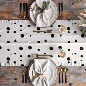aranżacja stołu z bieżnikiem w czarne grochy, talerze i złote sztućce